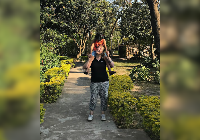Voluntaria cargando en hombros a una niña