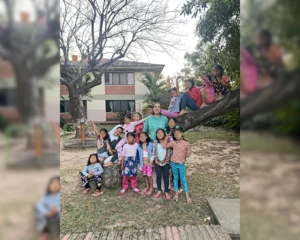 Voluntaria y religiosa con niños sobre un arbol