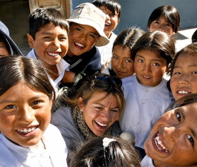 Carla y niños sonriendo juntos.