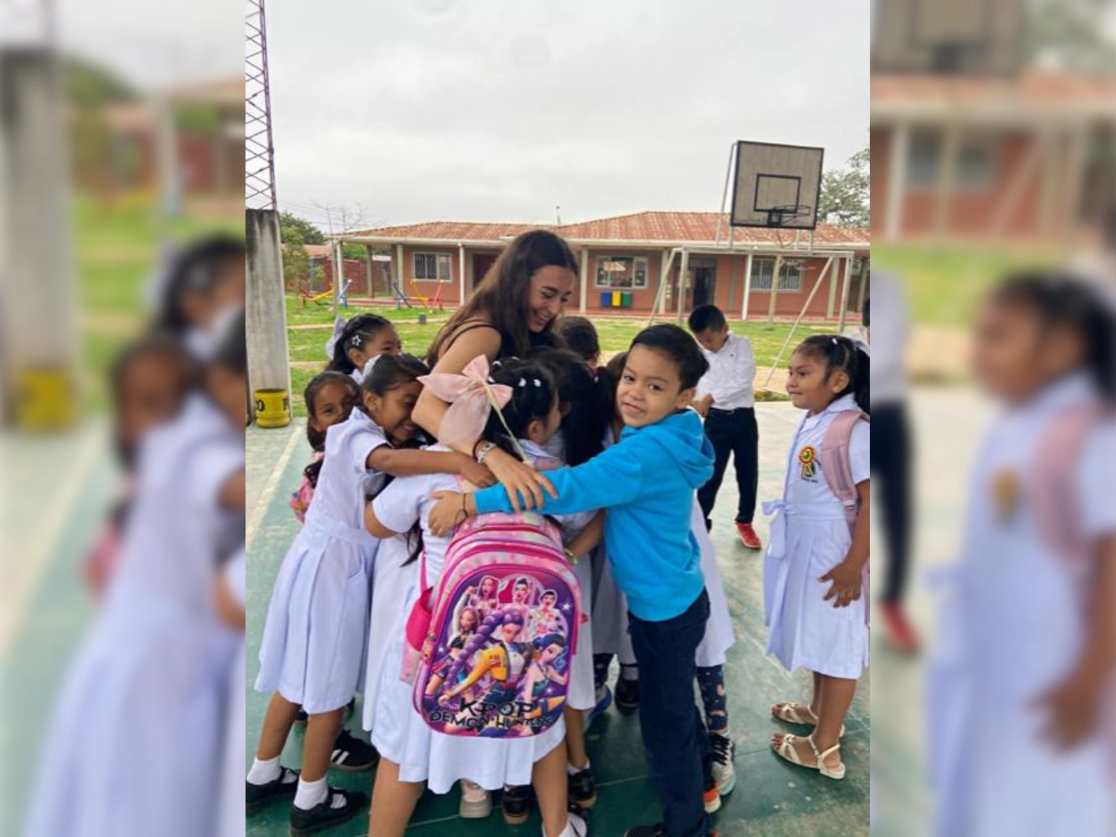Voluntaria con niños en la cancha